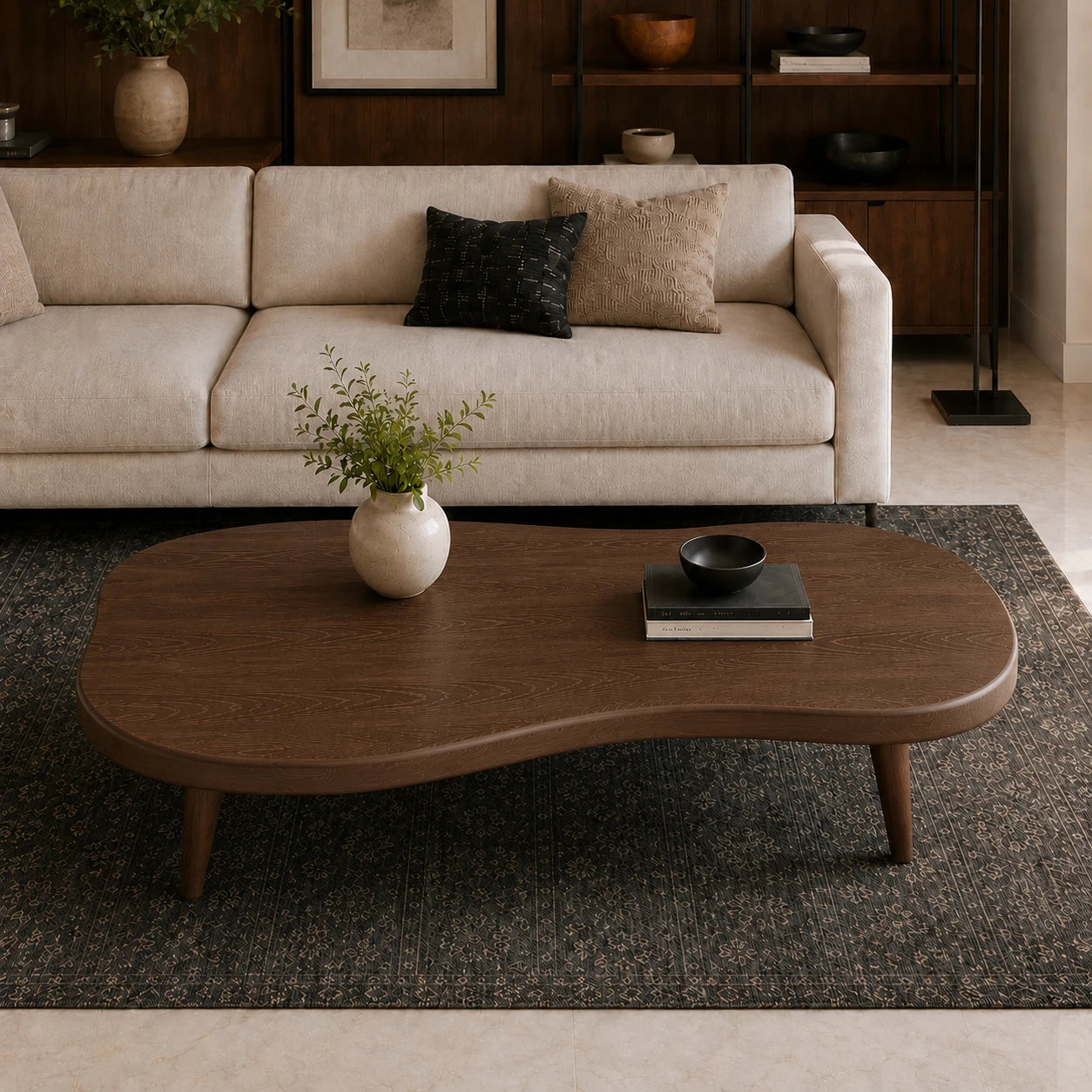 A modern wavy wooden coffee table in a warm medium brown finish, styled in a living room setting on a dark textured rug in front of a cream-colored sofa.