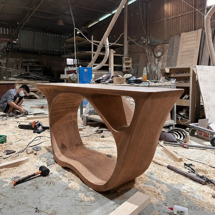 Arboriswood sculptural solid wood console table with looped base being finished by a craftsman
