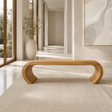 Sculptural bench with open arch base and smooth solid wood form for serene interiors