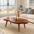 Coastal coffee table with freeform solid wood top and tapered legs in a bright beach room