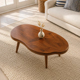 Low profile coffee table with irregular curves and handcrafted legs in a coastal home