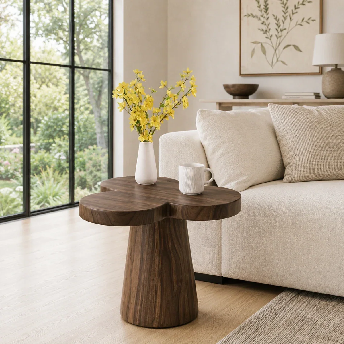 Curved side table adds floral character and practical surface to a serene bedroom space