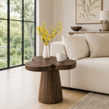 Curved side table adds floral character and practical surface to a serene bedroom space