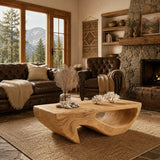 With a carved open base, this coffee table anchors a warm rustic living room setting