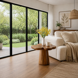 Organic modern side table styled by soft seating in a bright garden view interior