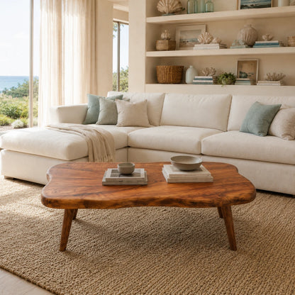Low profile coffee table with sculpted edges and tapered legs in a bright coastal room
