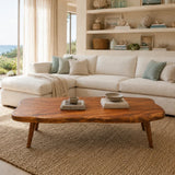 Premium coffee table with sculpted contours and tapered legs in a sunlit coastal interior