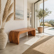 Sculptural bench with waterfall ends and solid wood form in a bright coastal hallway