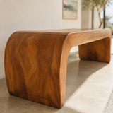 Designer bench with rounded waterfall silhouette and solid wood build for modern spaces
