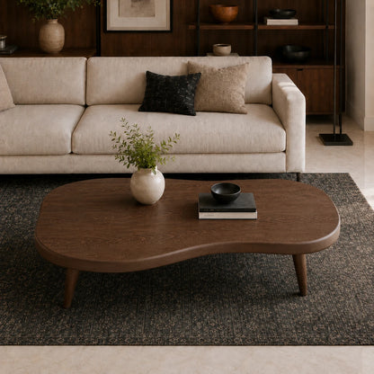 Statement coffee table with soft irregular curves and slender legs for refined interiors