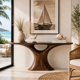 Wood tone console table with sculpted central base and elegant seaside home styling