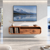 Refined wall mounted media unit in solid wood with shelving and drawer storage below

