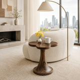 Curved side table adds sculptural character and practical surface to serene interiors