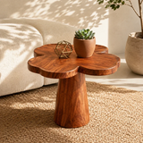 Sculptural end table with flower shaped top and warm wood tone finish in a bright room