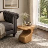 Luxury side table with a flowing pedestal base and rounded top in an airy interior