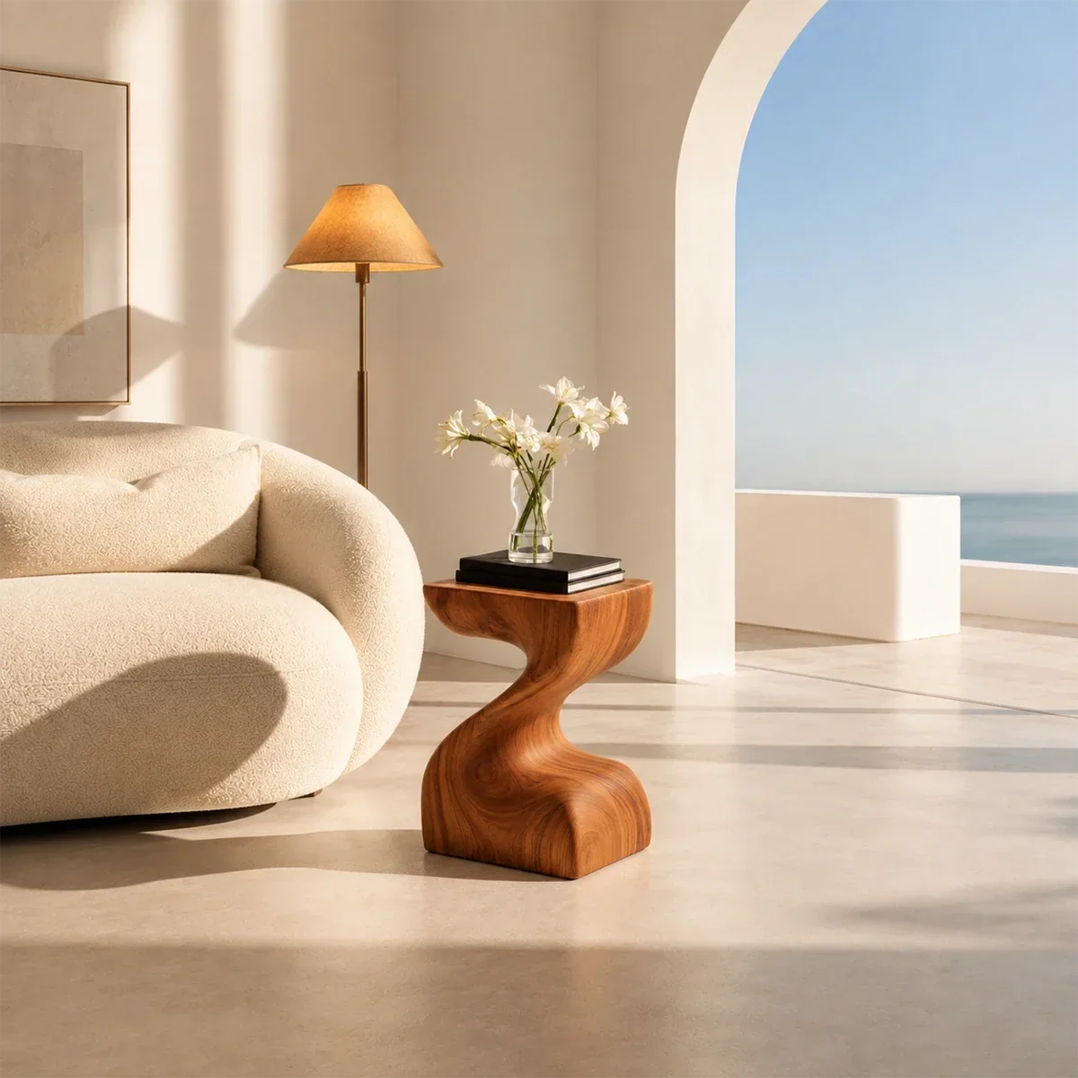 Organic modern side table styled beside curved seating in a bright neutral interior