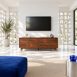Mid century media console in solid wood with four drawers and brass pulls below TV
