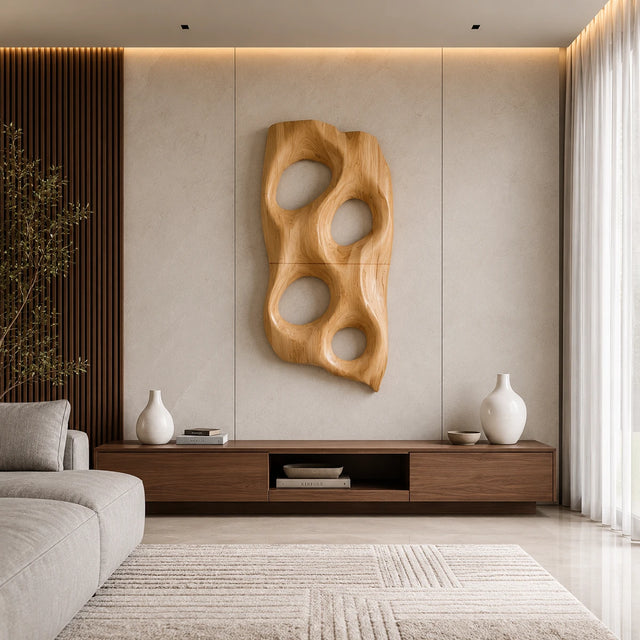 Sculptural wall art with rounded openings creates a bold focal point above a console