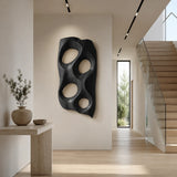 Large decorative wall panel with carved voids creates visual interest in open spaces