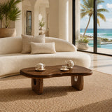 Artisan coffee table with visible grain and rounded form in a calm seaside interior