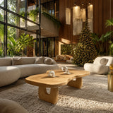 Statement coffee table with flowing silhouette and rich wood tone in a serene beach room
