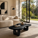 Luxury coffee table with organic edges and sculpted supports near ocean view windows