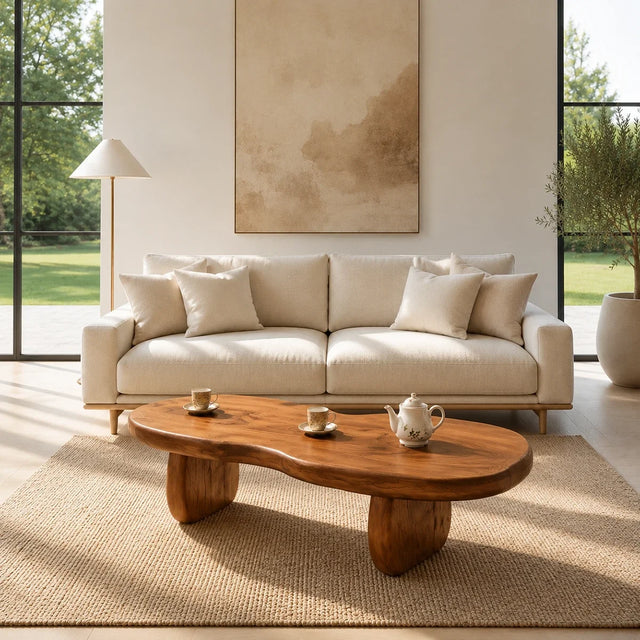 A sculptural coffee table with freeform top styled in a calm modern living room setting