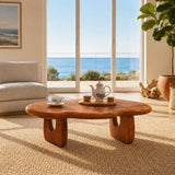 Artisan coffee table with visible grain and rounded form in a calm seaside interior
