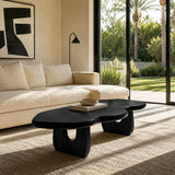 Luxury coffee table with organic edges and sculpted supports near ocean view windows
