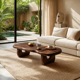 Sculptural coffee table with organic top and carved supports in a bright tropical room