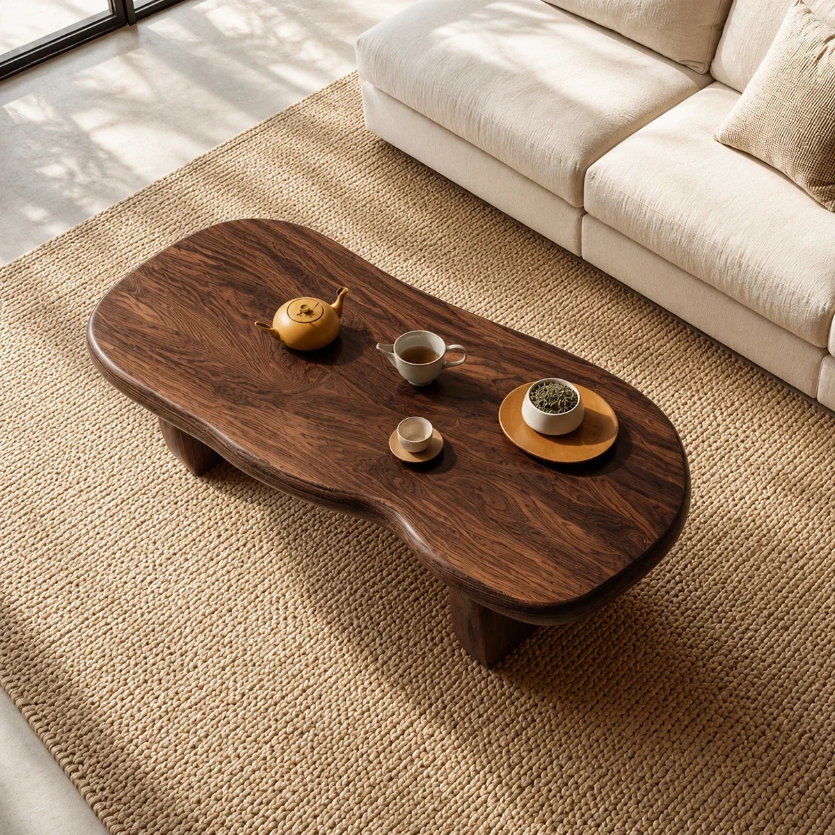 Modern coffee table with flowing contours and sturdy supports beside a curved sofa