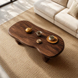 Modern coffee table with flowing contours and sturdy supports beside a curved sofa