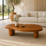 Minimalist coffee table with a low organic profile and wide solid wood legs for airy rooms