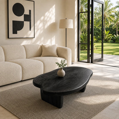 Contemporary coffee table with rounded edges and low solid wood legs in a sunlit interior