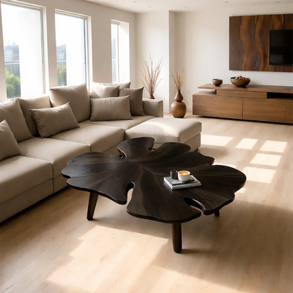 Coffee table in black stain with artistic base design and soft curves in a bright modern interior