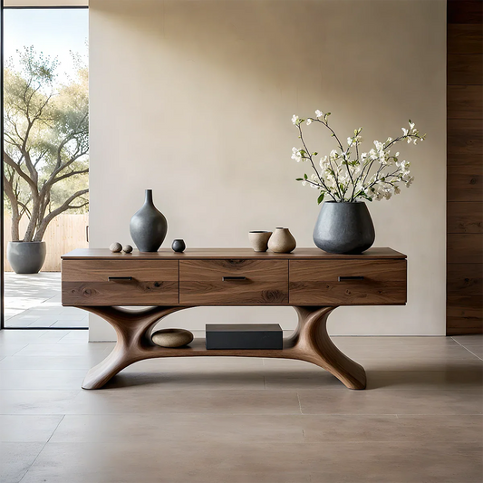 Modern console table with sculpted base and natural wood finish featuring drawers in minimalist interior