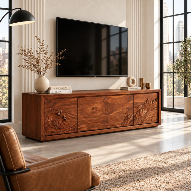 Solid wood TV stand with carved wave and mountain relief across four storage doors
