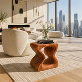 Sculptural end table with open curves and warm wood tone finish in a bright living room