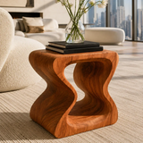 Designer side table with flowing cutouts and visible grain in a luxury living space