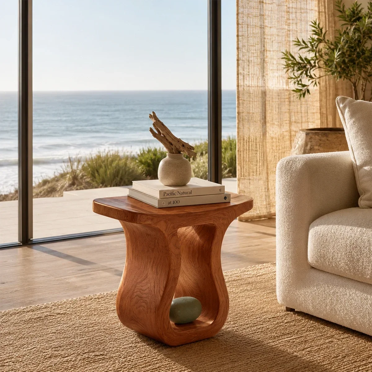 Sculptural end table with open base and warm wood tone finish in a bright coastal room