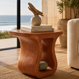 Designer side table with flowing cutout form and compact surface in a calm interior