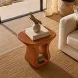 Curved side table adds sculptural character and practical surface to airy interiors