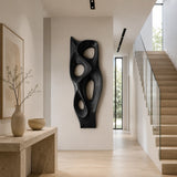 Modern wall sculpture with flowing negative space enhances a bright minimalist interior