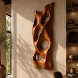 Vertical wall decor with carved voids creates a striking focal point in an open interior
