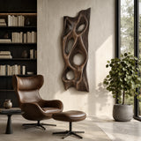 Textured wall art with deep open forms introduces visual rhythm to a contemporary space