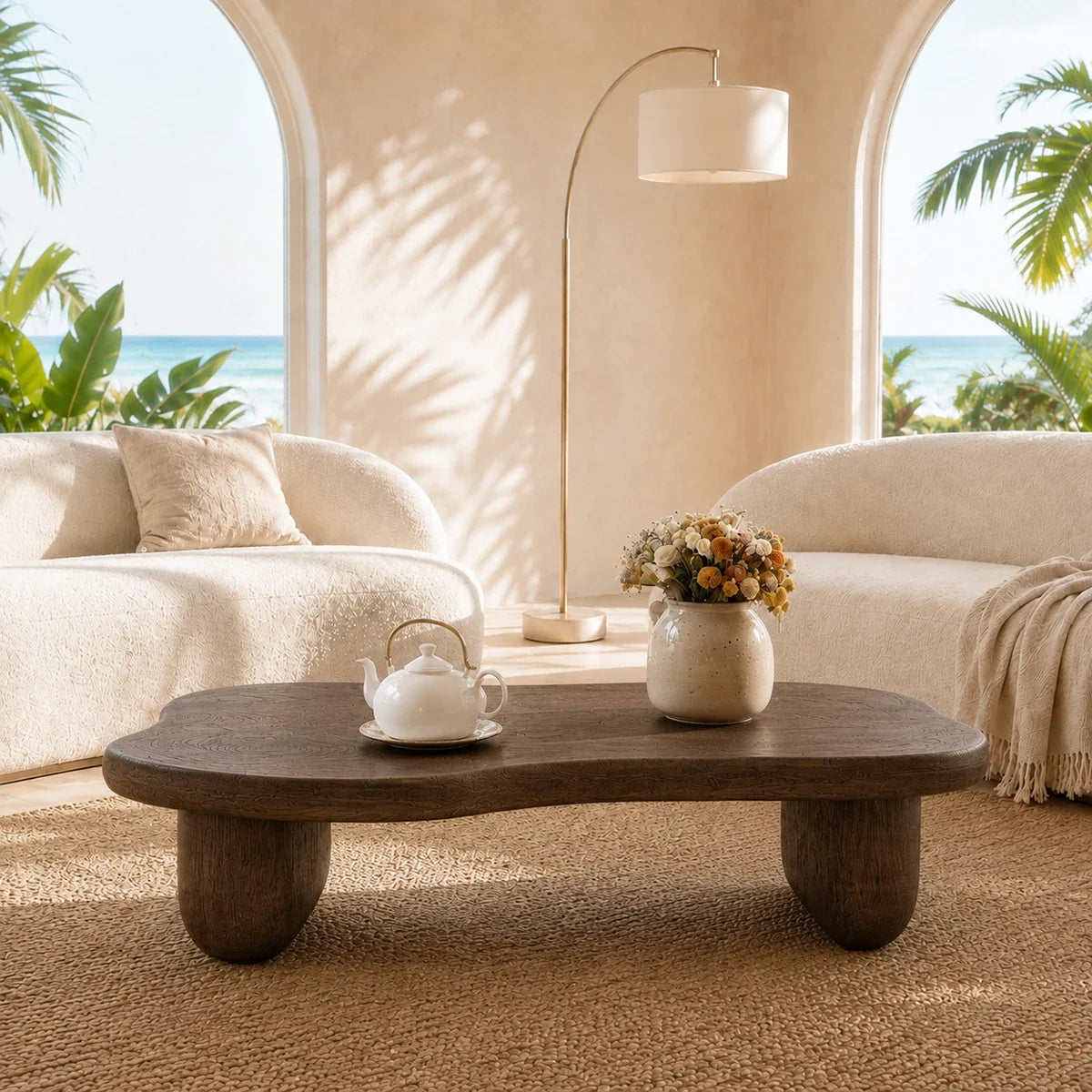 Living room coffee table with sculpted top and warm dark finish in a sunlit interior