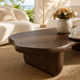 Designer coffee table featuring a broad sculpted top and sturdy curved base indoors