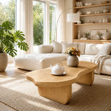 Statement coffee table with organic silhouette and dark wood tone in a minimalist room