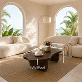 Contemporary coffee table showcases flowing curves and rich wood tone in an airy room