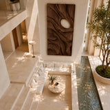 Open form wall sculpture with sweeping relief creates visual rhythm in a modern setting